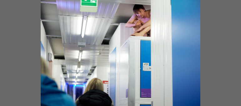 Ein Mann sitzt im Schneidersitz auf einem Lagerraum von MyPlace-SelfStorage